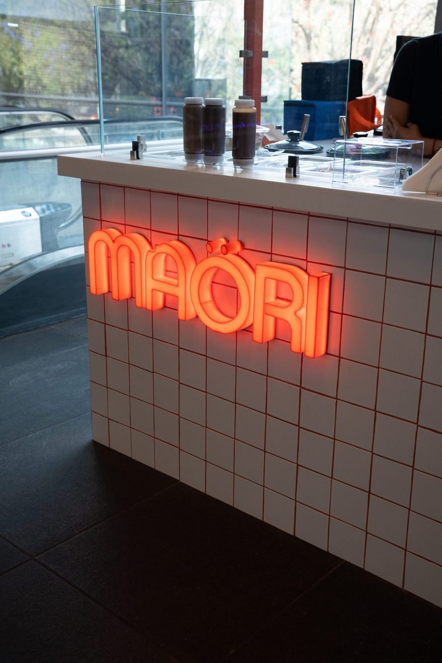 Mostrador con letrero neón de Maori